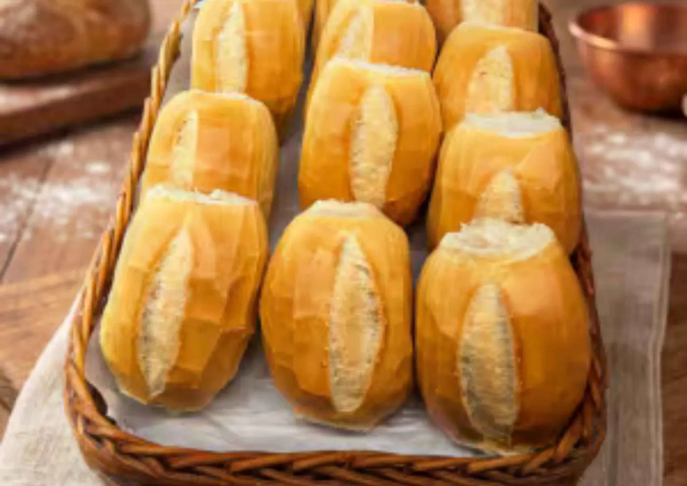 Cesta de vime com pães de sal dourados